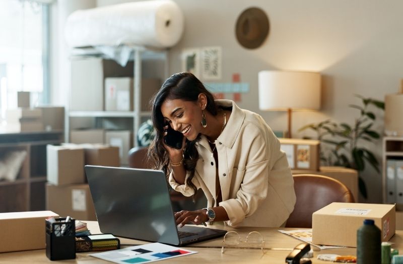 Woman working on a laptop while discussing a commercial property loan.